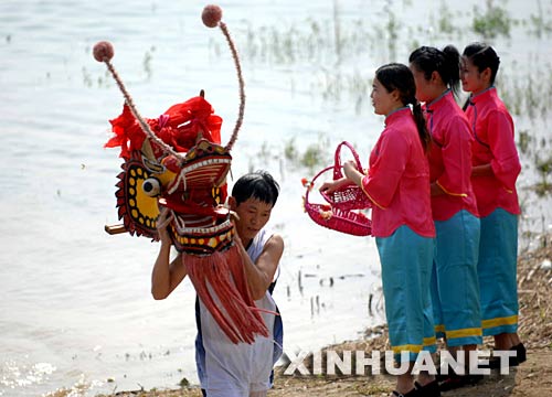 6月2日，一名龍舟隊(duì)員正在汨羅江邊祭龍頭。 當(dāng)日，“我們的節(jié)日·端午節(jié)”主題文化活動(dòng)暨第三屆中國汨羅江國際龍舟邀請(qǐng)賽在湖南汨羅市舉行。來自澳大利亞、荷蘭以及中國各地的十幾支龍舟隊(duì)在汨羅江參加角逐。汨羅是中國古代偉大詩人屈原晚年生活、創(chuàng)作和投江殉國之地。 新華社記者 李尕 攝 