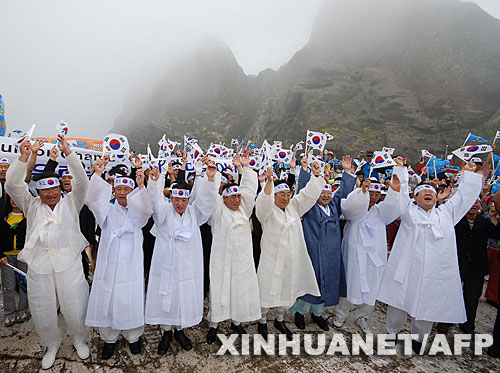  7月14日，大批韓國(guó)人在獨(dú)島（日本稱“竹島”）手舉國(guó)旗抗議。韓國(guó)外交通商部發(fā)言人文太暎當(dāng)日發(fā)表聲明，強(qiáng)烈抗議日本在當(dāng)天公布的中學(xué)教科書指導(dǎo)手冊(cè)中將獨(dú)島（日本稱“竹島”）表述為日本領(lǐng)土，并要求日本立即對(duì)有關(guān)內(nèi)容進(jìn)行修正。韓國(guó)外交通商部將采取召回韓國(guó)駐日本大使和召見(jiàn)日本駐韓國(guó)大使這兩項(xiàng)外交措施，就此問(wèn)題向日本政府表示強(qiáng)烈抗議。 新華社/法新 