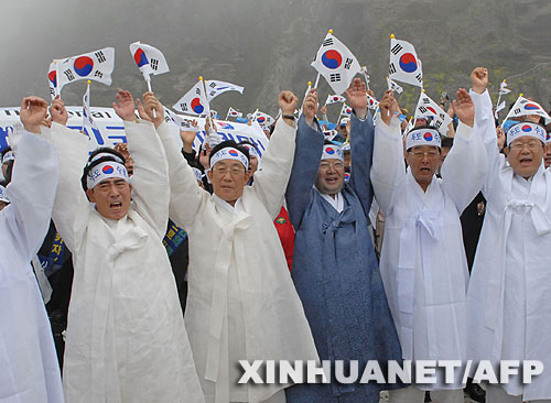 7月14日，大批韓國人在獨(dú)島（日本稱“竹島”）手舉國旗抗議。韓國外交通商部發(fā)言人文太暎當(dāng)日發(fā)表聲明，強(qiáng)烈抗議日本在當(dāng)天公布的中學(xué)教科書指導(dǎo)手冊中將獨(dú)島（日本稱“竹島”）表述為日本領(lǐng)土，并要求日本立即對有關(guān)內(nèi)容進(jìn)行修正。韓國外交通商部將采取召回韓國駐日本大使和召見日本駐韓國大使這兩項(xiàng)外交措施，就此問題向日本政府表示強(qiáng)烈抗議。 新華社/法新 