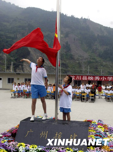 8月27日，映秀小學(xué)學(xué)生在板房校園內(nèi)升起鮮艷的五星紅旗。 新華社發(fā)