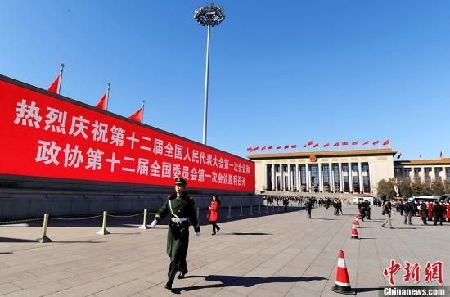 3月4日，北京晴空萬里，武警從北京天安門廣場大型顯示屏前走過。3月5日上午，十二屆全國人大一次會議將隆重開幕。中新社發(fā) 劉忠俊 攝